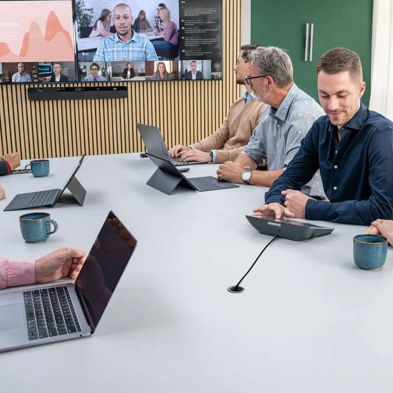 Shure IntelliMix Bar Pro installed below a display in a meeting room