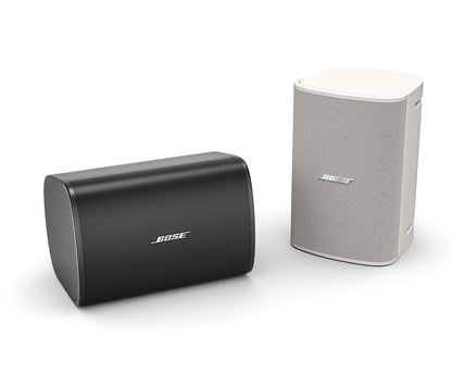 Bose DesignMax DM5SE white surface mount loudspeaker, shown alongside the black version